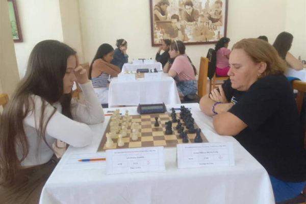 Tres ajedrecistas abrazadas en la cima por corona de ajedrez en Cuba