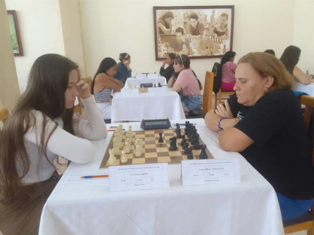 Tres ajedrecistas abrazadas en la cima por corona de ajedrez en Cuba